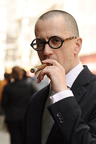 Male with round glasses and cigar on location in Chelsea